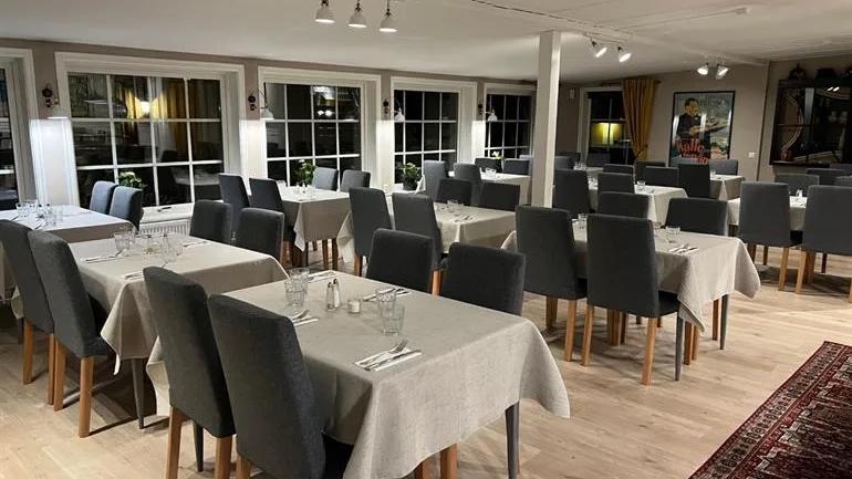 En inbjudande restaurang med flera dukade bord och stolar, belägen i en ljus och luftig lokal.