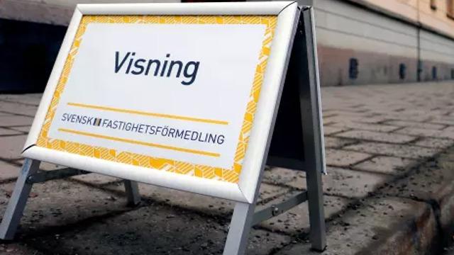 Visningsskylt för Svensk Fastighetsförmedling på en trottoar.
