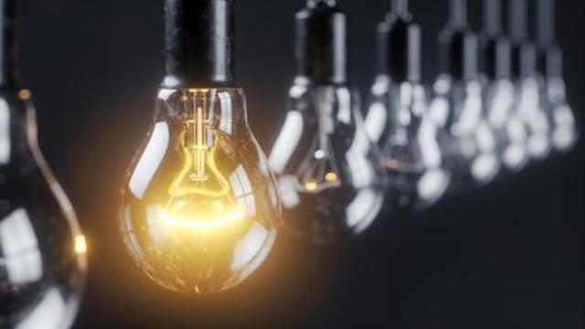En rad med glödlampor, där en lampa lyser starkt med ett varmt, gyllene sken.