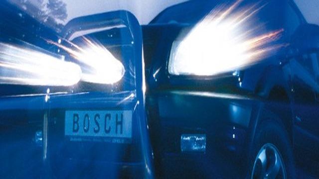 En svart bil med starka strålkastare som lyser, med en registreringsskylt som visar "BOSCH".